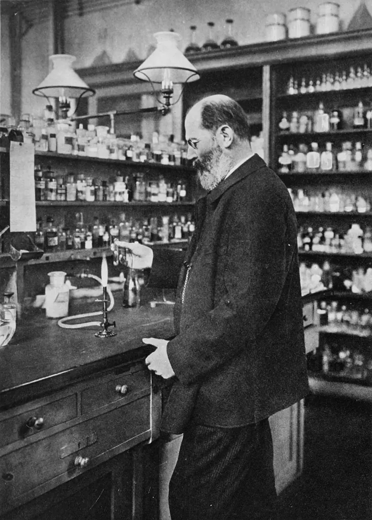 Emil Fischer de pie en su laboratorio privado de Berlín, rodeado de frascos